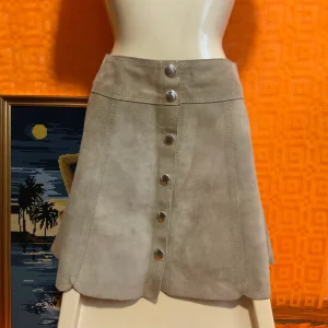La mini jupe boutonnée Seventies Daim Iconique